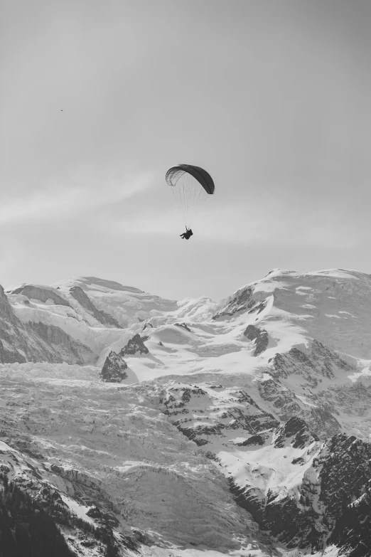 a parasailer is being towed over a snowy landscape