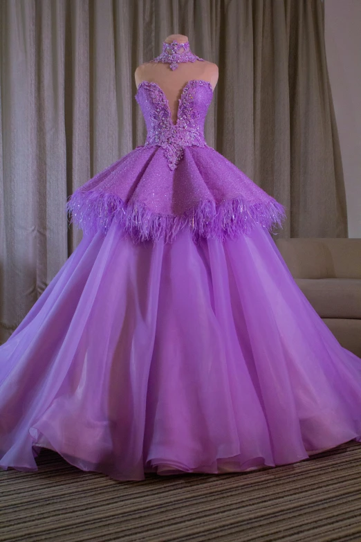 a purple gown is on display in front of curtains