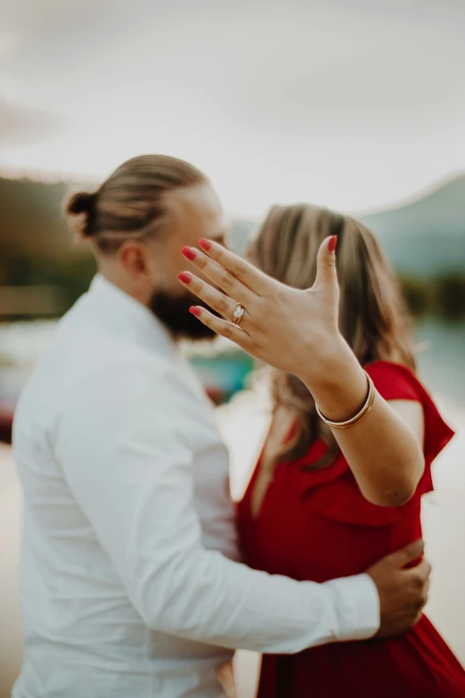 an engaged couple is touching each other with their hands