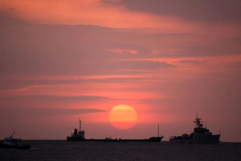 a sunset over some water with boats in the water