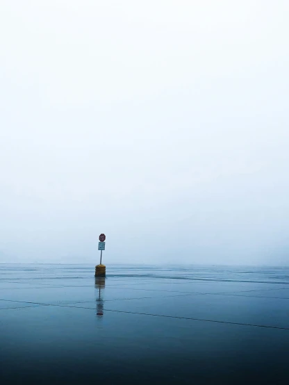 two people in the water, standing on a buoy