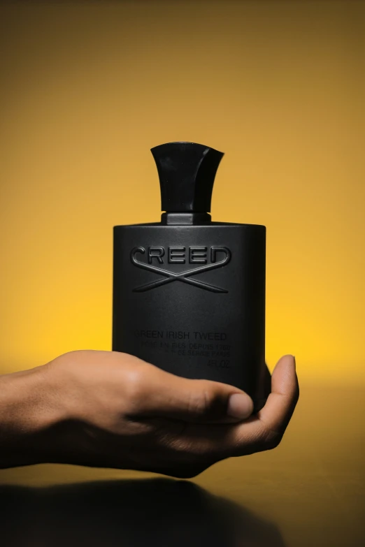 the person holds a small black flask that is in their hands
