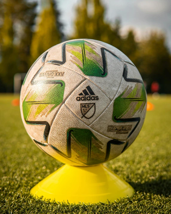 a soccer ball on a yellow pedestal in the middle of a field