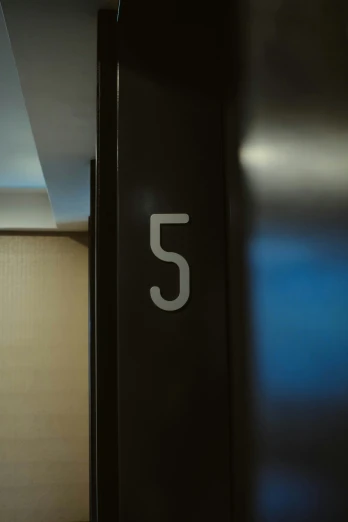 the number 5 on a black door is white