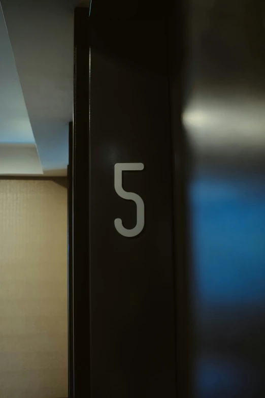 the number 5 on a black door is white