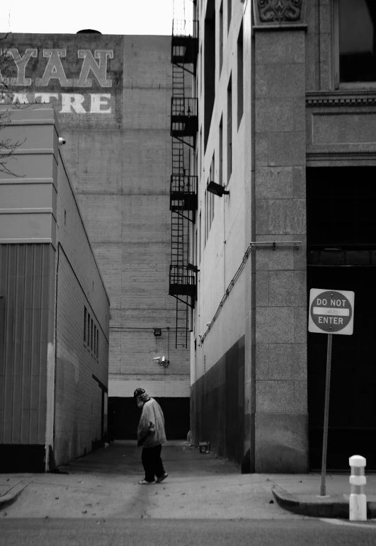 a man is walking down a sidewalk toward an industrial building