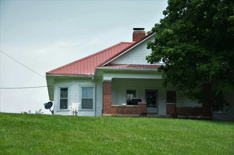 a large home with a red roof sits on a hill