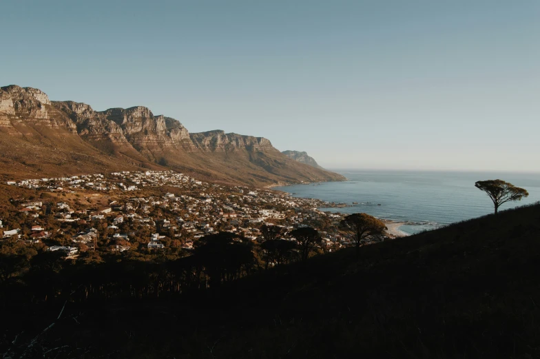 a mountain with a city on the side and a body of water