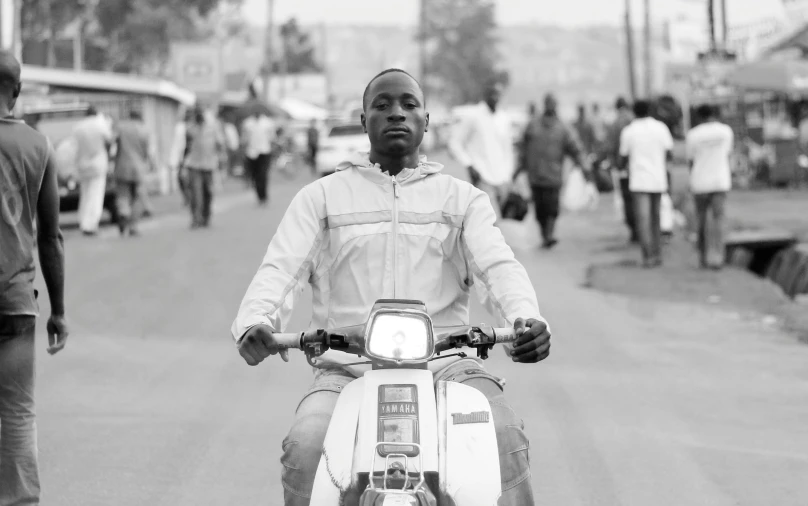 a man riding on the back of a white moped
