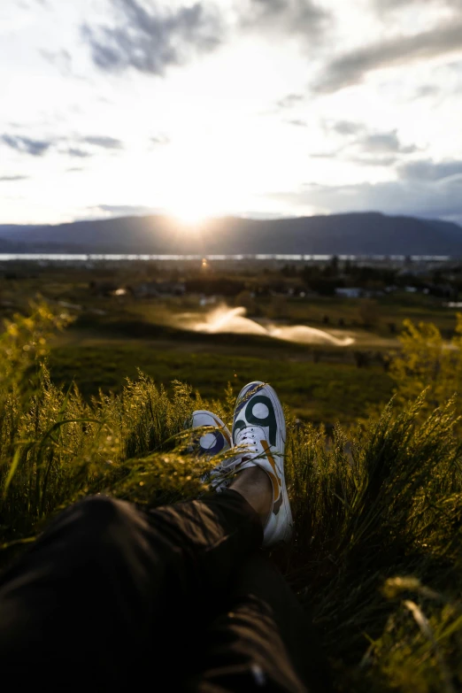 someone has their shoes on while standing in the grass