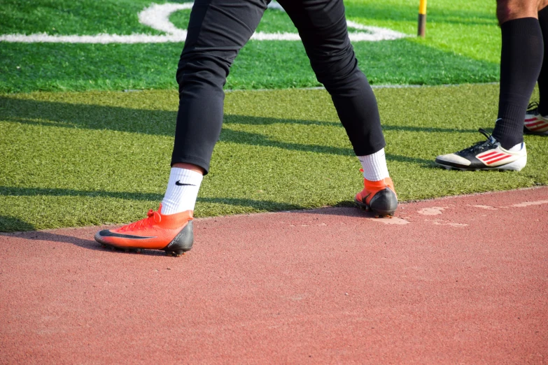 a pair of feet are wearing red shoes