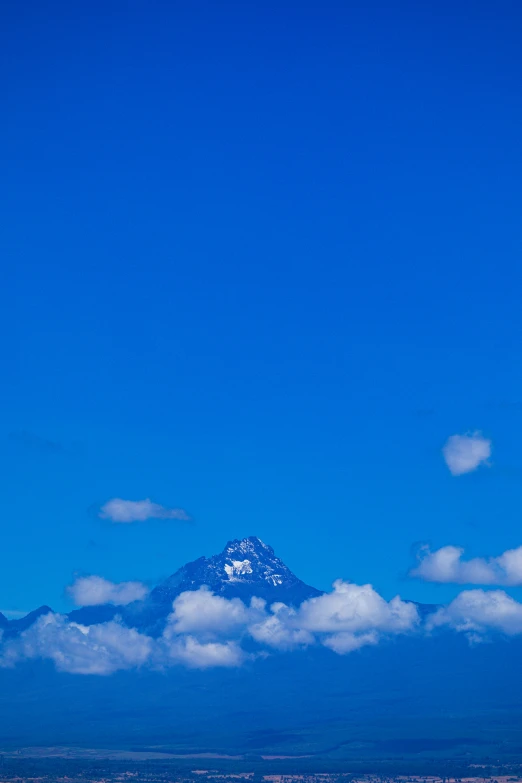 some boats on a body of water and a big snow capped mountain