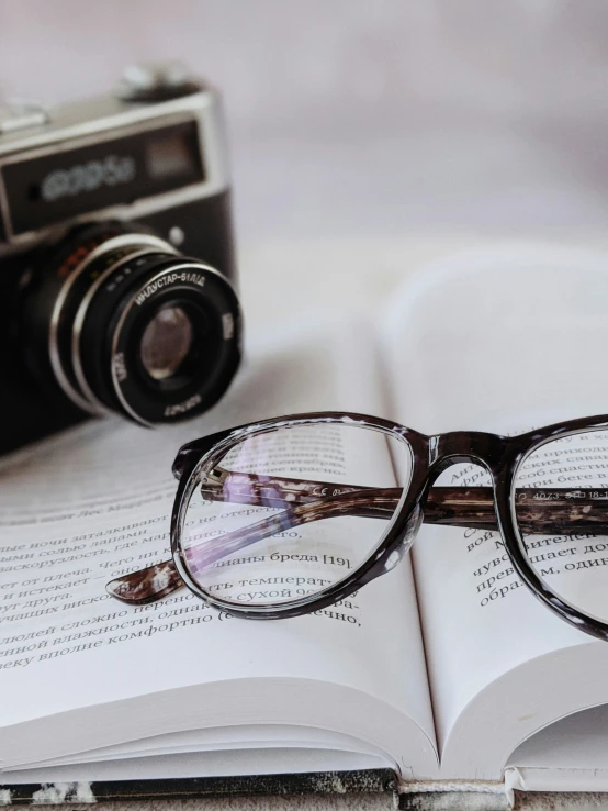 a book open on a table next to a pair of glasses