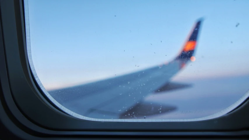 an airplane wing seen through the window of the airplane