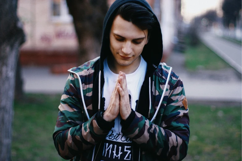 a young man praying with his hands together
