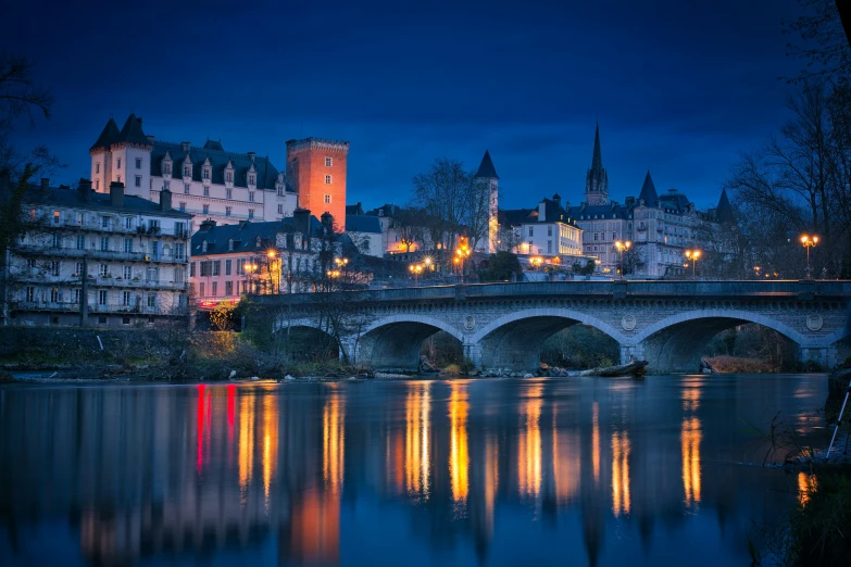 buildings reflected in the water next to a bridge