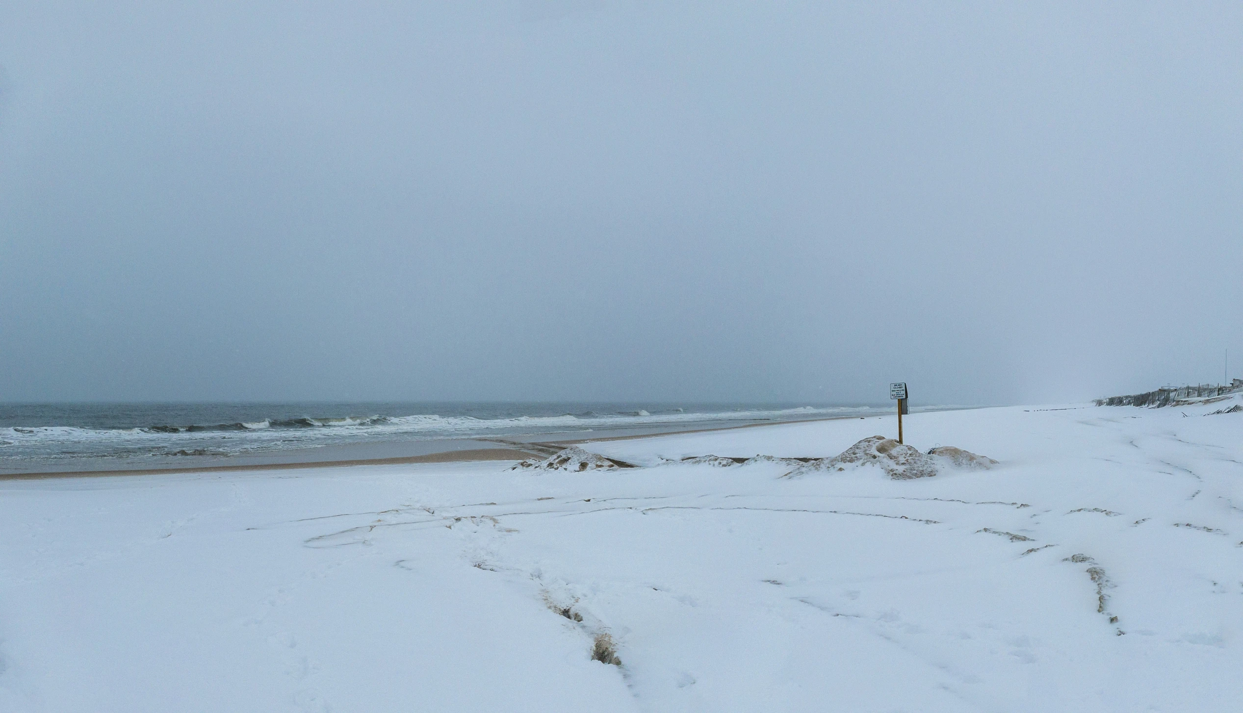 an ocean shore covered in white snow