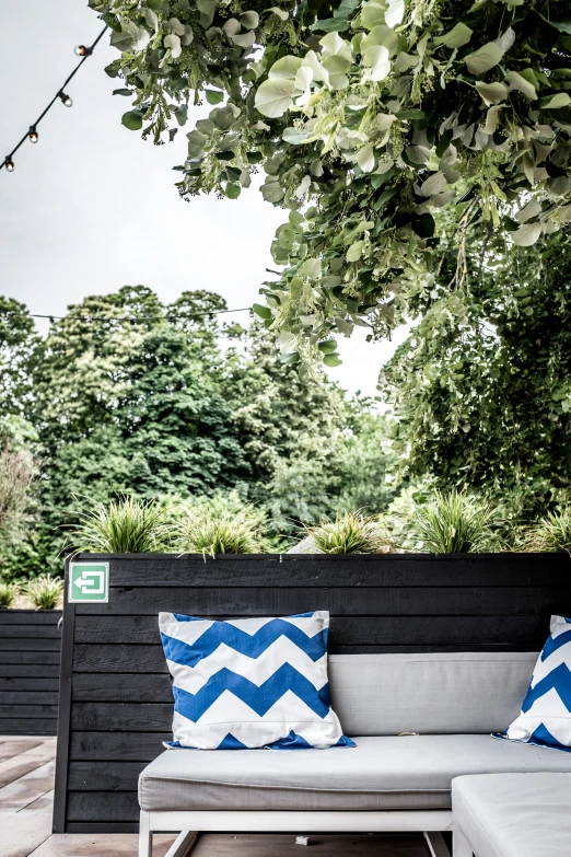 a gray and blue bench sitting under a tree