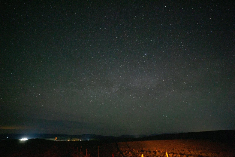 some dark colored stars that are above some trees