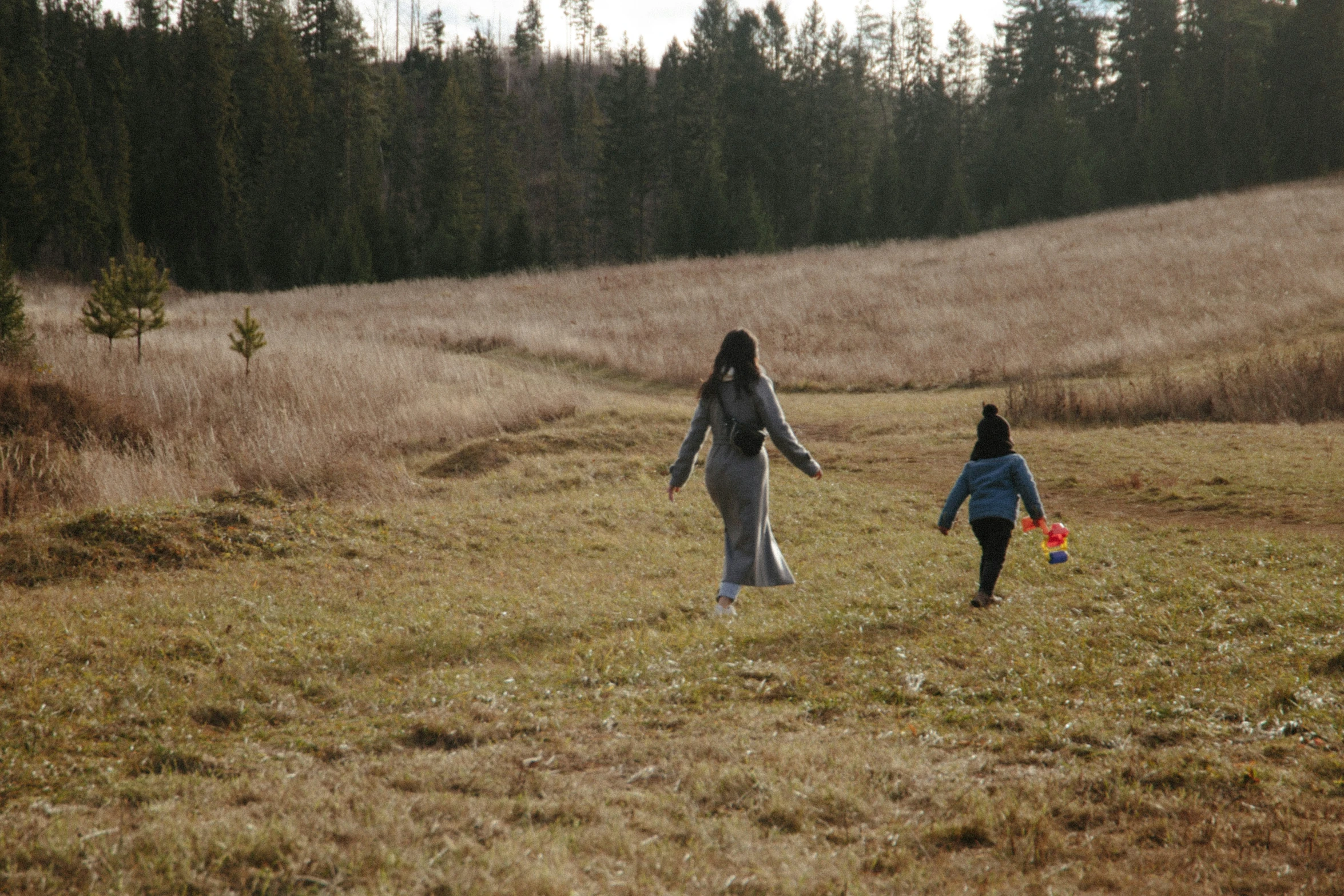 two women are walking in the middle of an open field