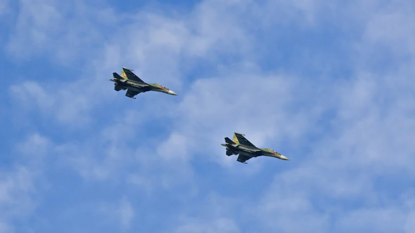 two planes in the air with a cloudy sky