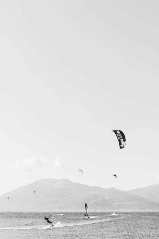 a black and white po of two windsurfers in the water