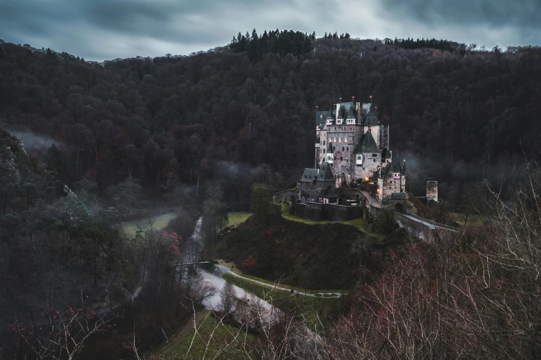 an aerial po of a castle with fog in the background