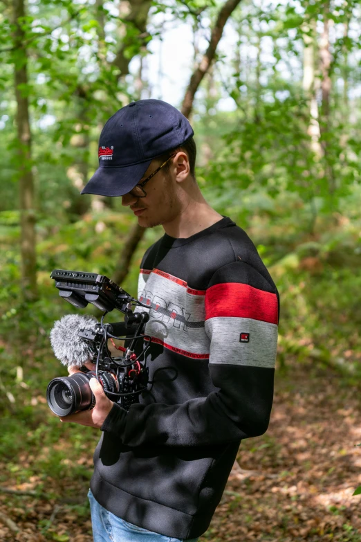 a man holding a camera and some trees