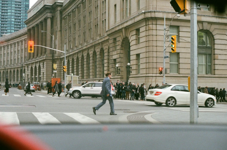 people walking in the street by buildings and cars