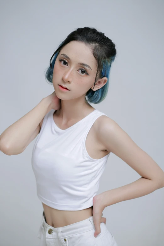 a young asian woman with dyed hair standing against a wall