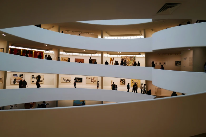 an art museum with people walking around the building