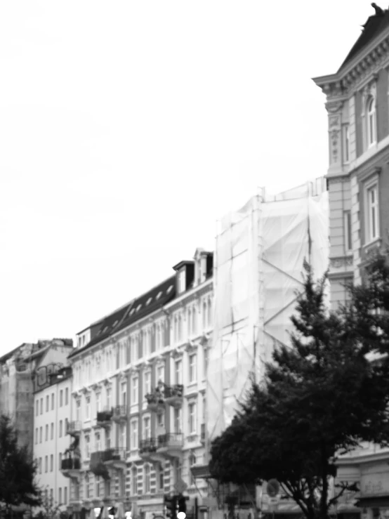 people standing on a corner near a building with many windows