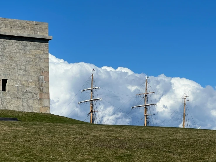 a tall brick building with three masted sail boats