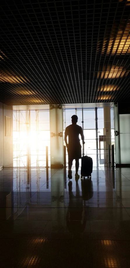 a man walking in the shadows with a suitcase