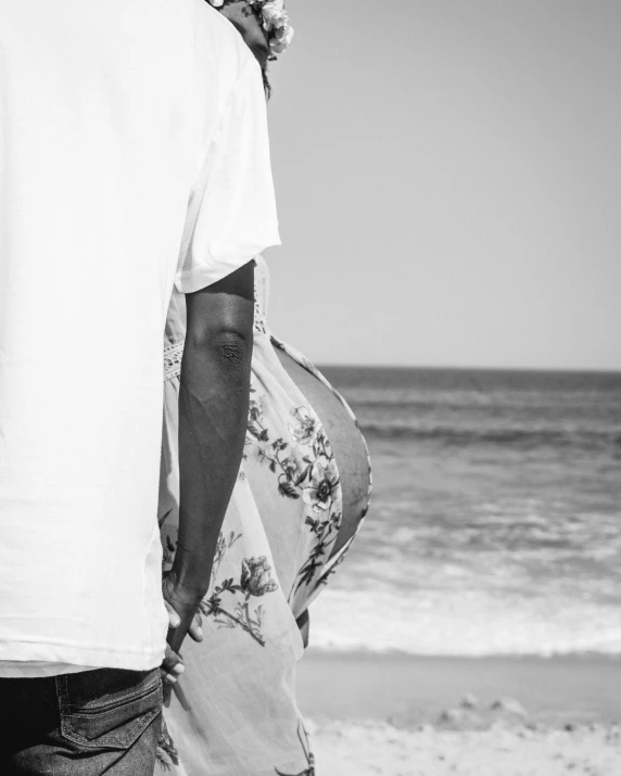 the man is standing on the beach holding his back to his bag