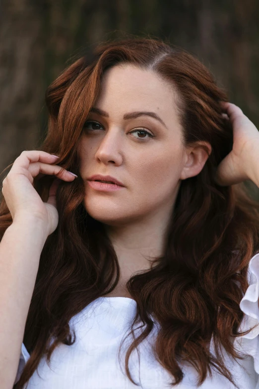 a woman with red hair is posing for the camera