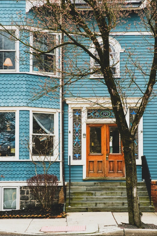 a blue house with stairs leading to the door and window