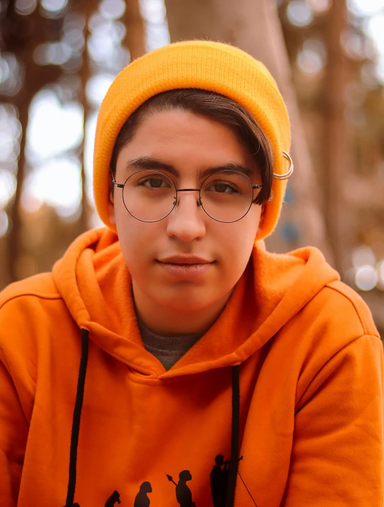  in an orange hooded sweatshirt looking pensively