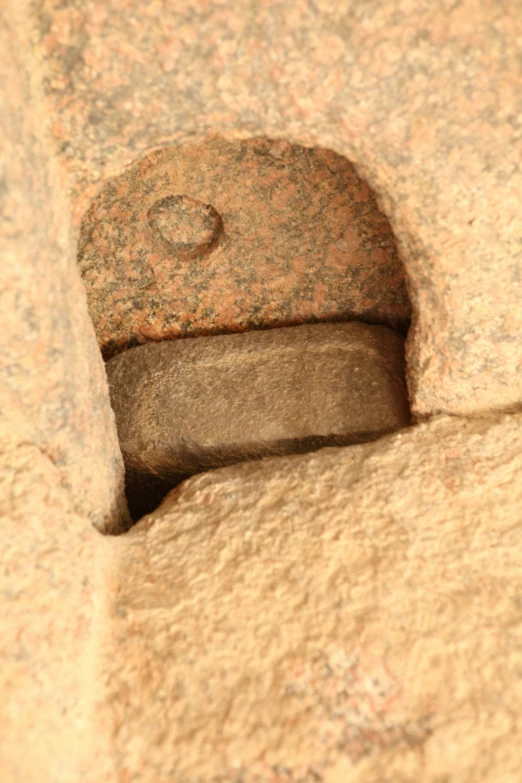 close up of a piece of iron in a stone wall