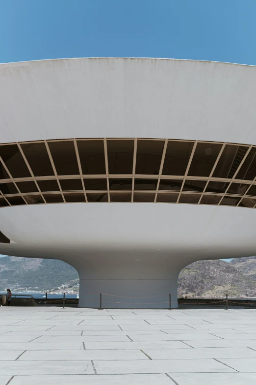 a very large white structure with some brown roofing on top of it