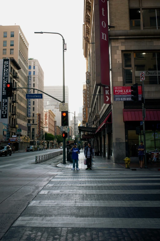 a couple walking in the cross walk of a city