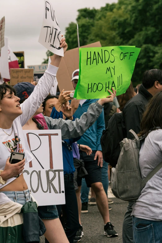 a group of protesters are holding signs with handwritten messages