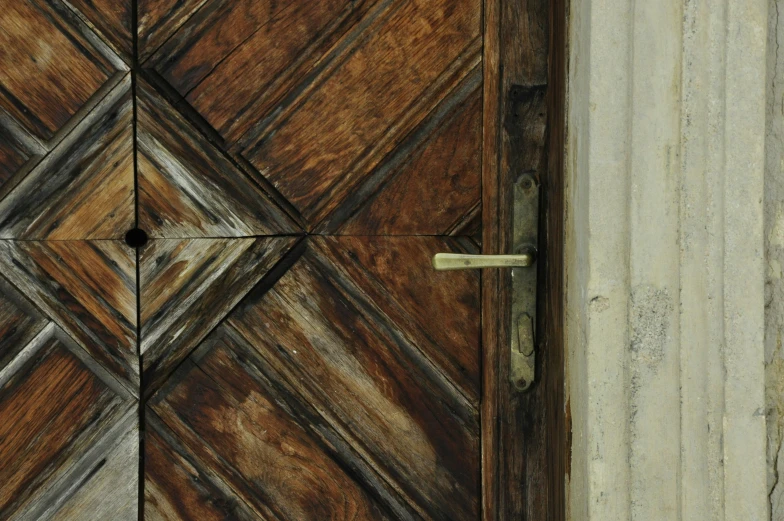 a wood door with metal latch in an old building