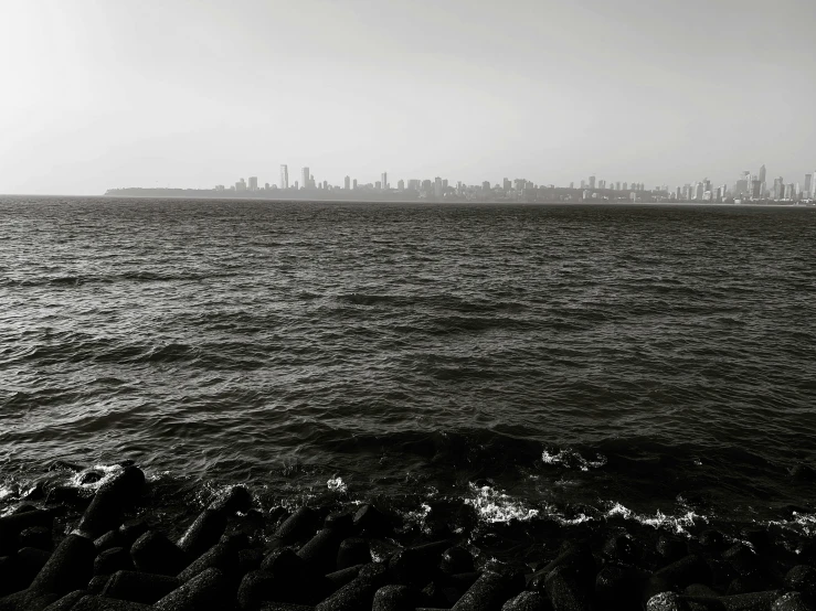 an industrial area in the distance with the ocean and skyscrs on the horizon