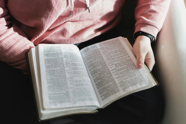 someone holding open a book on top of their lap