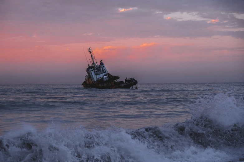 a large boat in the ocean at sunset