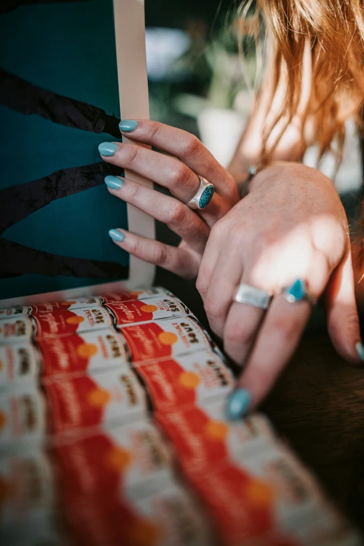 woman with manicured nails holding onto a book