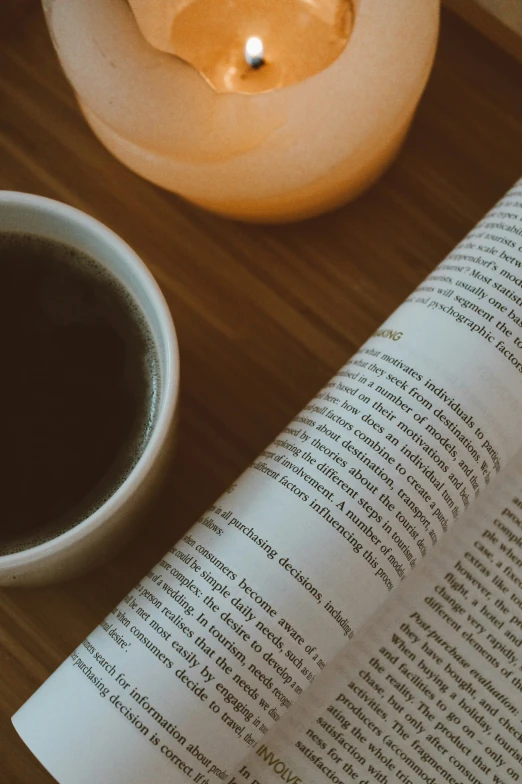 a book with coffee and a candle light