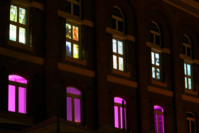 the windows in this building are lit up purple and green