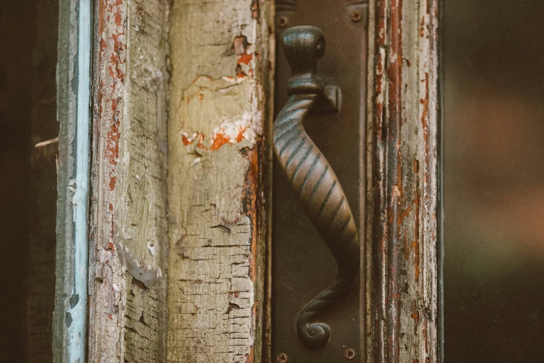 a weathered and battered door handle on an old building